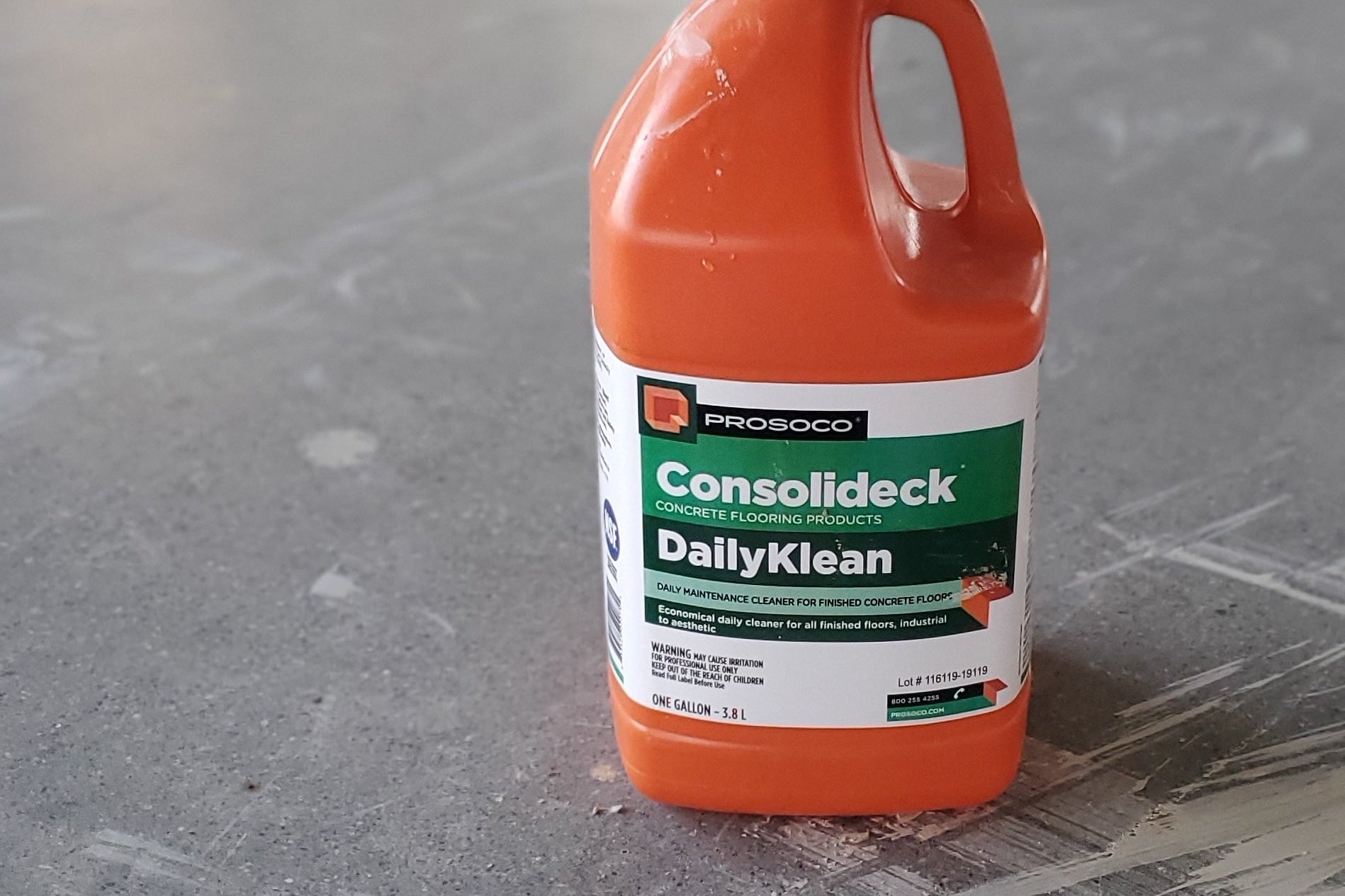 Orange bottle of Prosoco Daily Klean on Polished Concrete